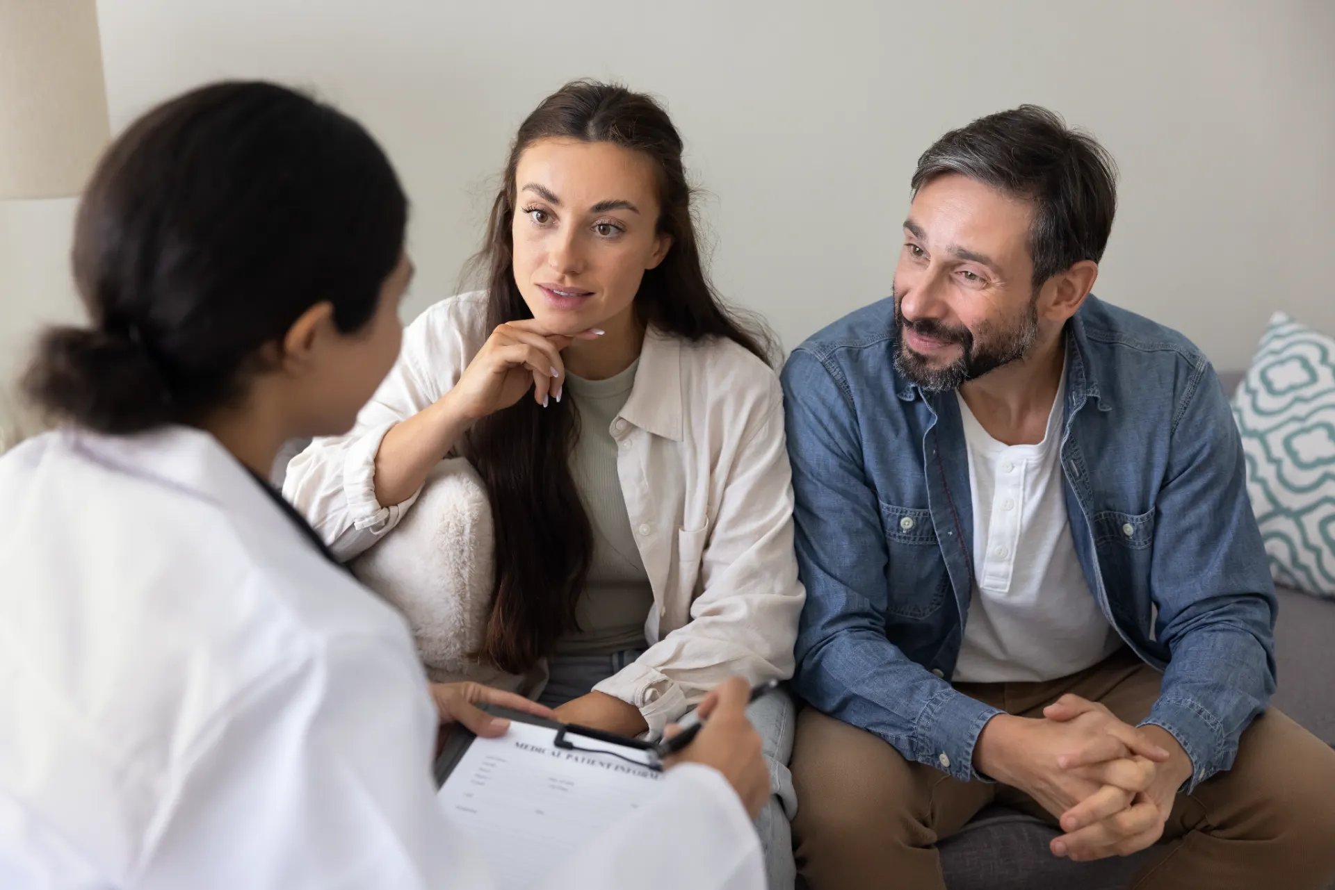 A CREI specialist talking with two patients in a consulting room.
